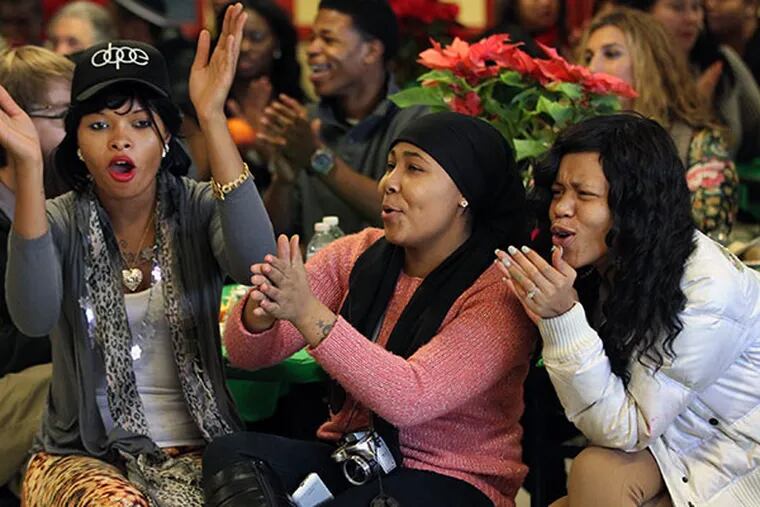 From left to right, Donna Varner, 19, Onyel Rose,17, and Mekkah Granger, 18, all students at Arise Charter, react to the news that they would be receiving a new coat and two new pair of sneakers as a gift from Villa Sports, a Philadelphia sports company. ( MICHAEL BRYANT / Staff Photographer )