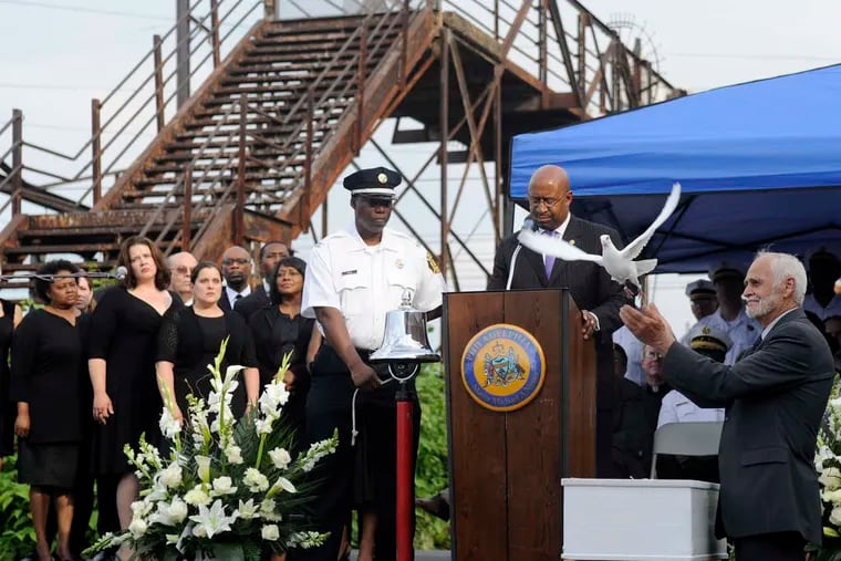 Mayor Nutter and others watch as a dove is released during a service at Frankford Junction on Sunday. One dove was released for each person who died in the Amtrak crash.