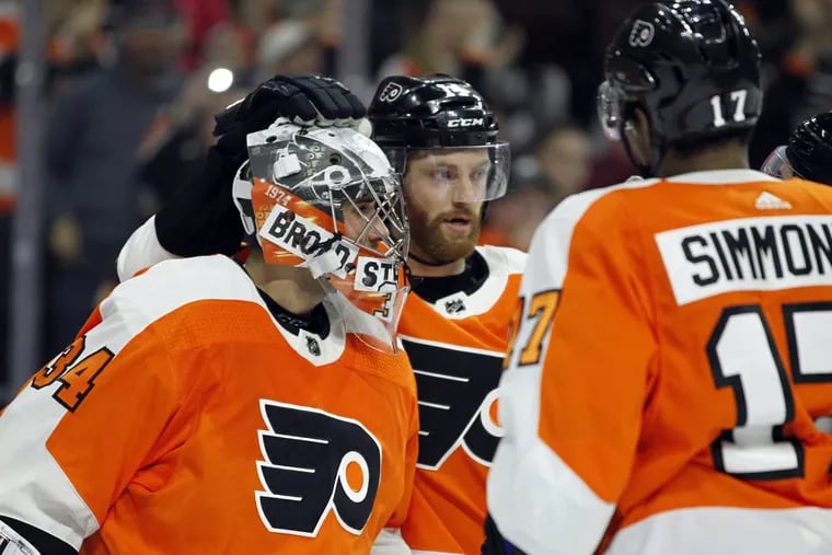 Flyers goalie Petr Mrazek and Sean Couturier (center) celebrate the 2-1 win over the Winnipeg Jets.