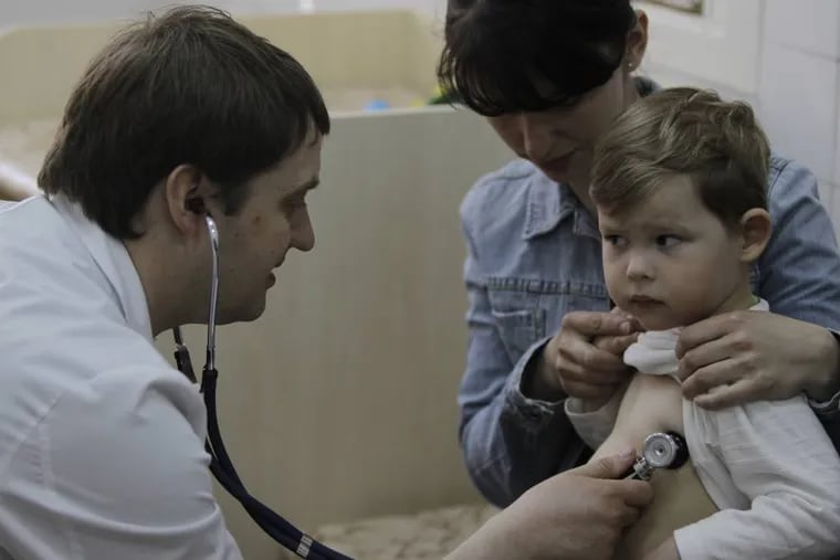 In this Monday, April 23, 2013 photo pediatrician Fyodor Lapiy examines a child before administering him a combined vaccine against diphtheria, whopping cough and tetanus  in Children's Hospital No. 1 in Kiev,Ukraine. Only about one-half of Ukraineâ€™s children are fully immunized against vaccine-preventable communicable diseases in line with local health regulations, compared to over 90 percent in Western Europe, according to UNICEF, the United Nations childrenâ€™s agency. Such a low immunization rate has already led to a major outbreak of measles and a risk of an outbreak of polio, a highly dangerous disease which may cause paralysis and which has been unseen in Ukraine for more than a decade, UNICEF and the World Health Organization said ahead of the current World Immunization week.  (AP Photo/Sergei Chuzavkov)