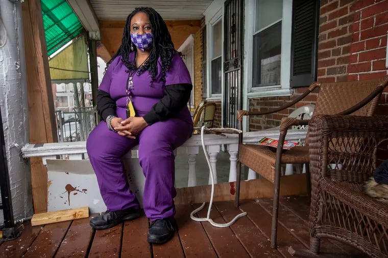 Lolita Owens, a home health aide, sits outside a client's West Philadelphia home. She was initially worried about getting a COVID-19 vaccine, but changed her mind after listening to education meetings organized by her union.