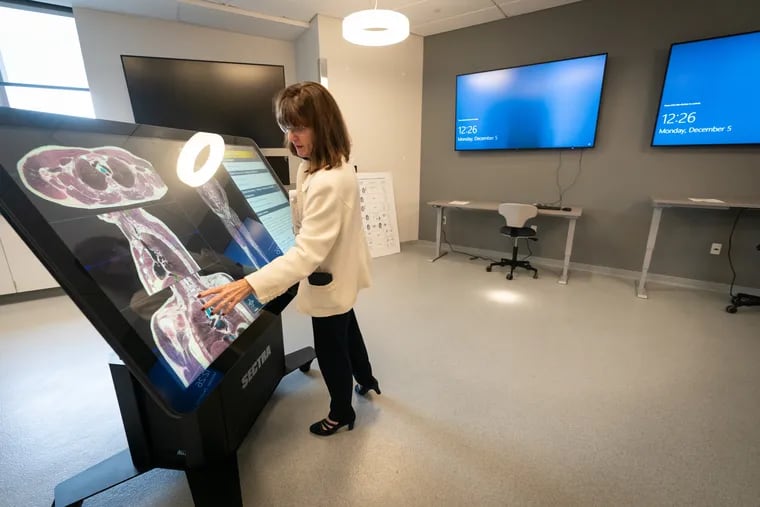 Mary Gallagher Gordon, vice dean, strategic operations and academic services at Drexel University's College of Nursing and Health Professions, shows off a new “Spectra” table, which allows students to read instructions on one screen, manipulate a 3D model of a human body on the other, and project their work on screens around the room so that others can see. It's part of the new 460,000-square-foot health sciences building near Drexel's campus.