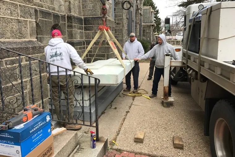 Workers remove the cover of a marble sarcophagus dedicated to the Rev. Francis A. Sharkey, founding pastor of the former Our Mother of Sorrows Catholic Church in the Mill Creek section of West Philadelphia.