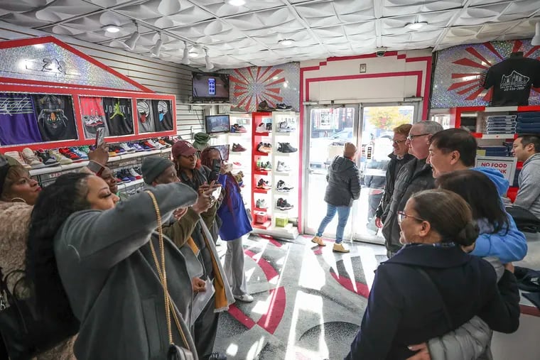 Yong Lee, owner of Young's Sneaker City on West Girard Avenue in Brewerytown, poses for photos with then-Mayor Jim Kenney during a November 2023 visit to his store.