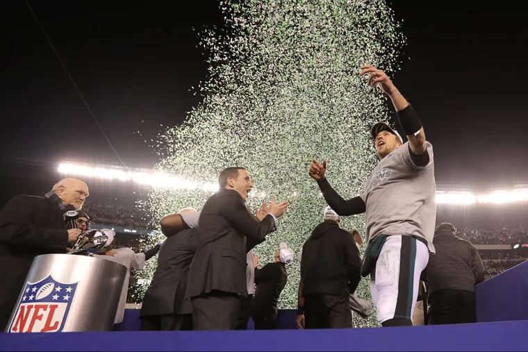 The Eagles’ Howie Roseman, center, celebrates with quarterback Nick Foles, right, after winning the NFC Championship, Jan. 21.