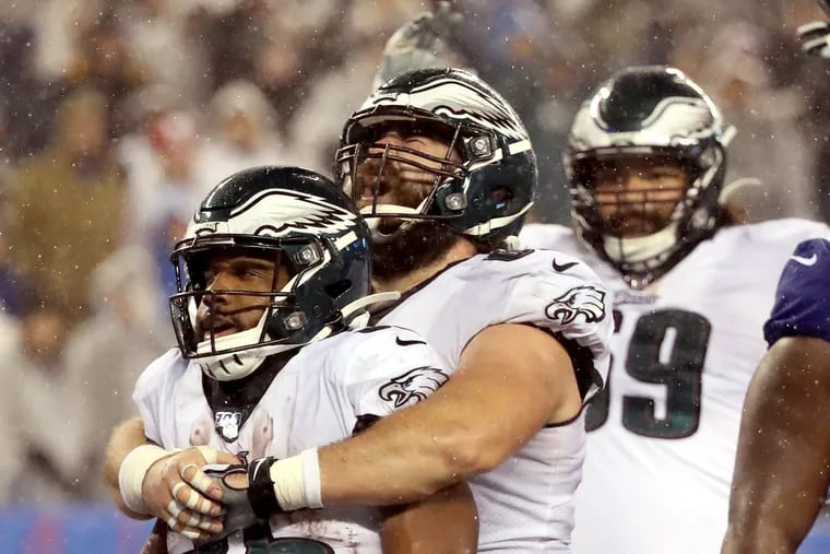 The Eagles' Boston Scott received a big hug from center Jason Kelce after scoring his third touchdown of the game in the Eagles' division-clinching win over the Giants last December.