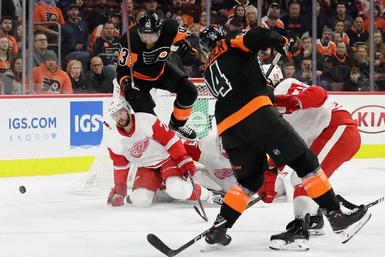Flyers right wing Jakub Voracek leaps over Detroit Red Wings defenseman Mike Green on Sean Couturier's third-period shot.