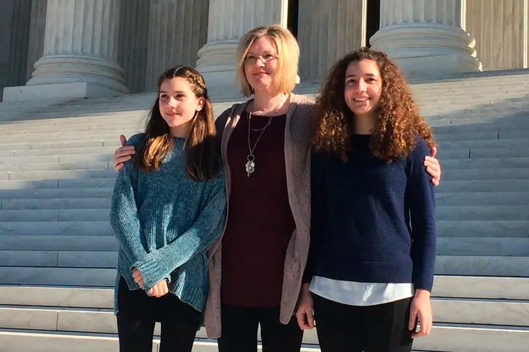 Kendra Espinoza of Kalispell, Montana, center, stands with her daughters Naomi and Sarah outside the U.S. Supreme Court, Wednesday, Jan. 22, 2020 in Washington. Espinoza is the lead plaintiff in a case the court heard Wednesday that could make it easier to use public money to pay for religious schooling in many states. Espinoza's daughters attend the Stillwater Christian School in Kalispell, near Glacier National Park.