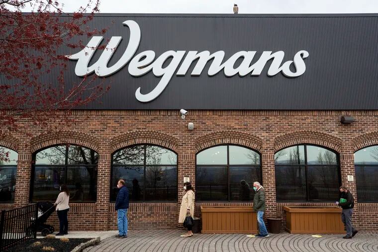 People practice social distancing while waiting in a line to enter a Wegmans grocery store in Dickson City, Pa., Thursday, April 23, 2020. (Christopher Dolan/The Times-Tribune via AP)