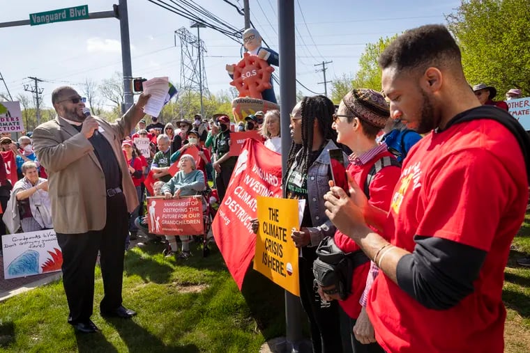 Bishop Dwayne Royster (left), executive director of POWER Interfaith Philadelphia,addressing activists against climate change campaign targeting Vanguard's investments in fossil fuels at protest outside Vanguard's Malvern headquarters on Earth Day, Friday, April 22, 2022.