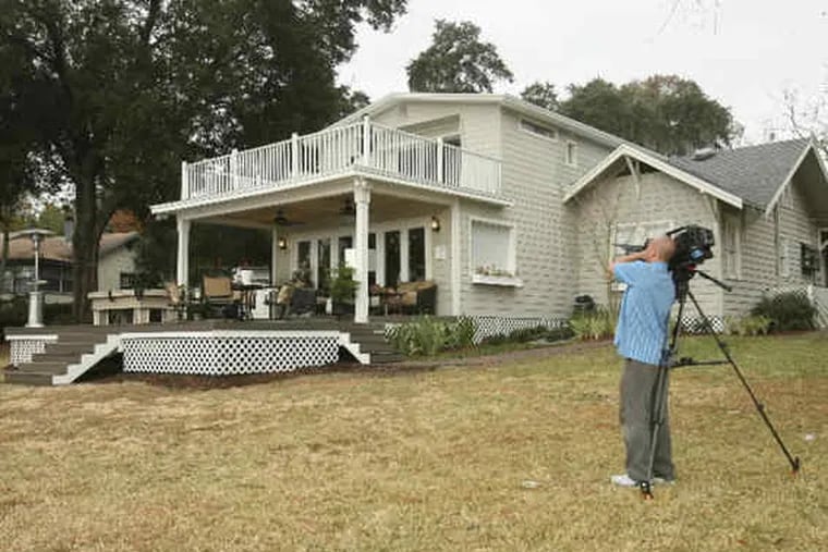 A cameraman for the DIY Network videotapes the remodeled porch at Tal and Charmon Shuford's home. Workers also built a walkway and added a misting system to discourage mosquitoes.