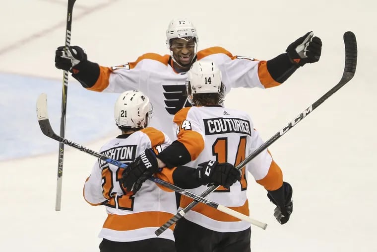 Flyers’ forward Sean Couturier celebrates his go-ahead goal against the Penguins with teammates Scott Laughton and Wayne Simmonds during the third period of game five.
