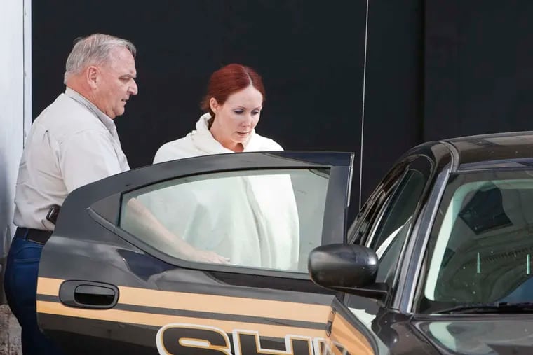 Shannon Guess Richardson gets into a sheriff's car in Texarkana, Texas. She has blamed her husband for poison sent to the president and others.