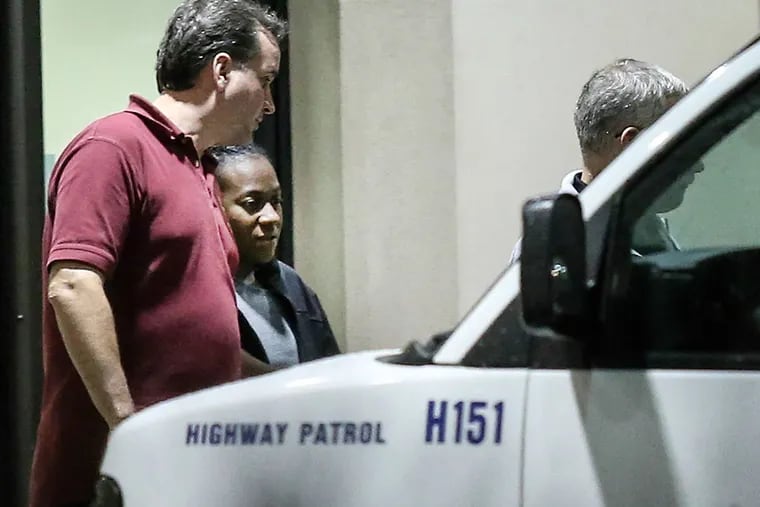 Carlesha Freeland-Gaither is escorted from Howard County General Hospital in Columbia, Md. early Thursday morning by Philadelphia Detectives James Sloan (left) and John Geliebter (partially obscured).