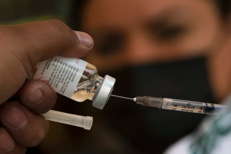 A health-care worker prepares a dose of the COVID-19 vaccine.