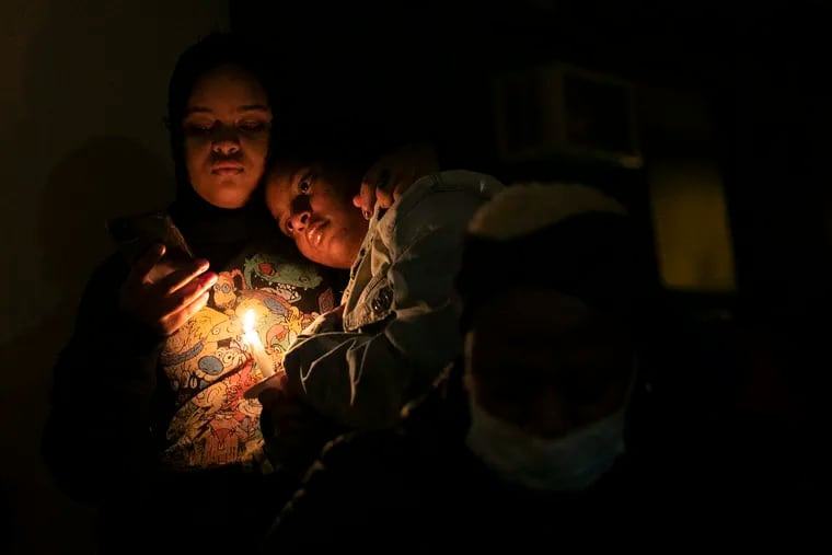 Family and community members gather for a vigil for the victims of the fatal fire by 23rd and Parrish in front of the Bache-Martin Elementary School at 22nd and Brown in the Fairmount section of Philadelphia, on Thursday, Jan. 6, 2022. The fire killed 12 people, including nine children, early Wednesday morning.