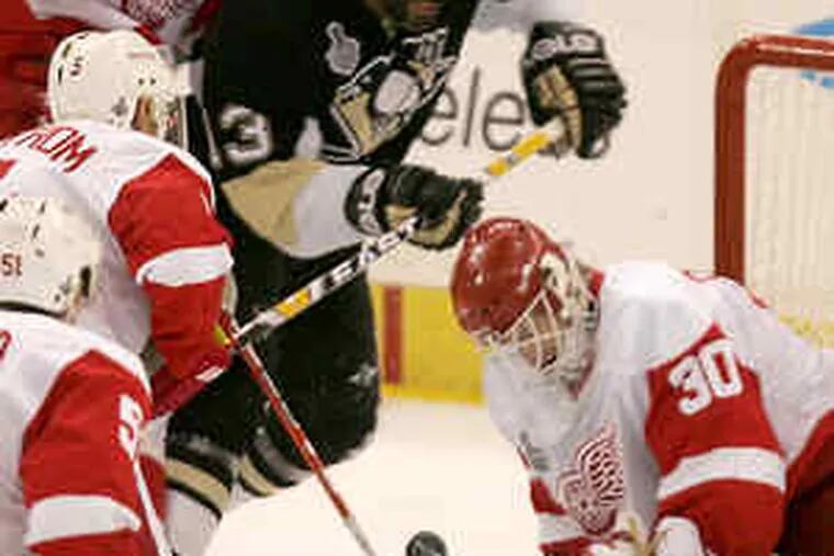 Red Wings goalie Chris Osgood makes a save against the Penguins' Bill Guerin during the first period in Pittsburgh.