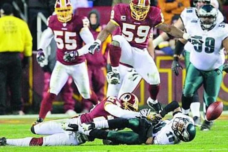 Redskins&#0039; Shawn Springs jars ball loose from Eagles wide receiver DeSean Jackson. Redskins linebacker London Fletcher leaps over both.