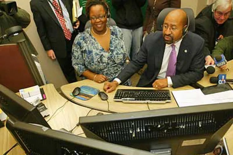 Mayor Michael Nutter answers the call of a Philadelphia resident looking for information through the city's new 311 Call Center. At left is Robin Aluko, 311 Contact Center Supervisior, assisting the Mayor with the phone call. (Alejandro A. Alvarez / Staff Photographer)