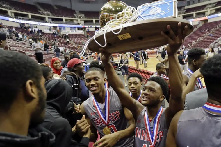 Imhotep players share the championship trophy with their fans after winning the boys’ Class 4A PIAA state championship on March 26.