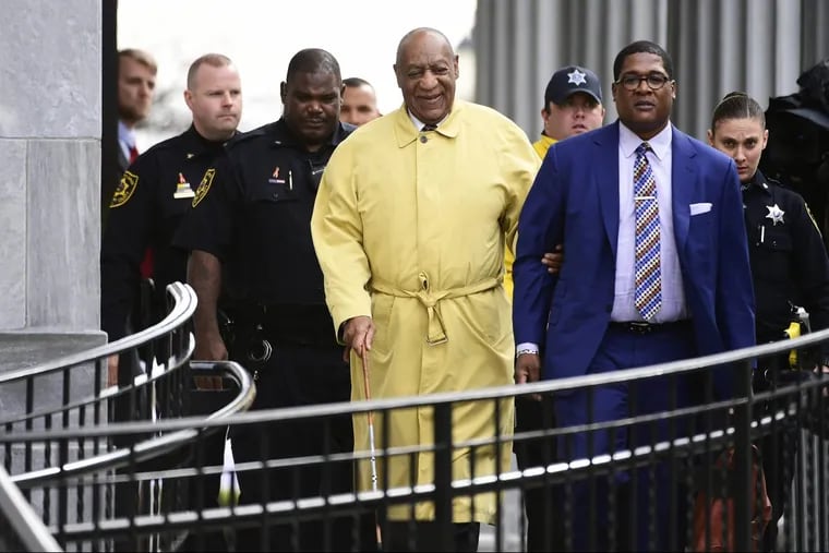 Bill Cosby, center, leaves the Montgomery County Courhouse after the first day of jury selection for his sexual assault retrial. He is led by spokesperson Andrew Wyatt, right.