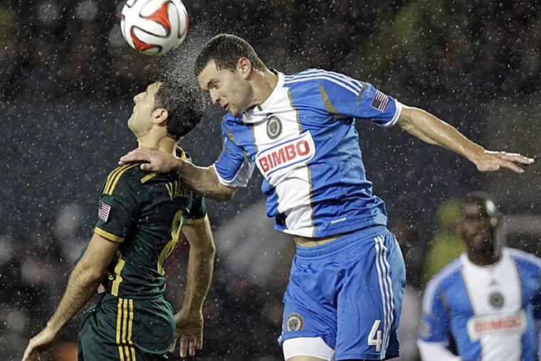 Union defender Austin Berry, right, heads the ball away from Portland Timbers midfielder Diego Valeri during the second half of an MLS soccer game in Portland, Ore., Saturday, March 8, 2014. The teams tied 1-1. (Don Ryan/AP)