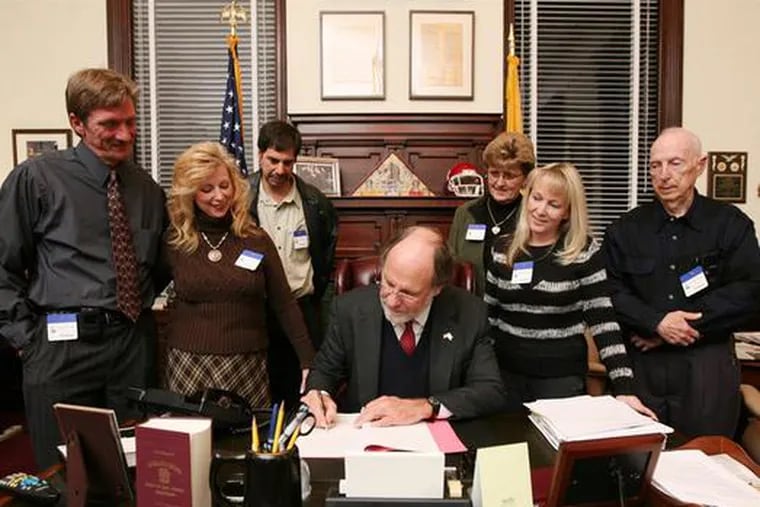 Robert and Kathy Corsini of Mantua (left) joined Gov. Corzine and other family members as he signed a bill intended to protect families of victims from high wrecked-vehicle charges.