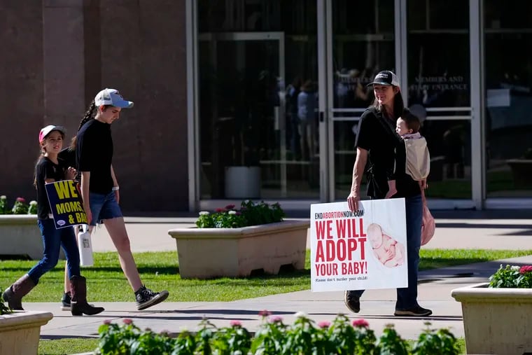 Pro-life demonstrators walk in the front of the Arizona Capitol prior to the vote on the proposed repeal of the state's near-total ban on abortions prior to winning approval from the state House in Phoenix.