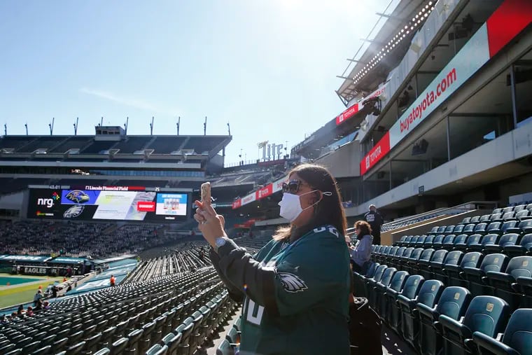 Eagles fan Lori Bruno of Reading, Pa., takes a photograph of Lincoln Financial Field before the Eagles played the Baltimore Ravens on Sunday. Due to COVID-19 restrictions, about 6,000 fans will be allowed to attend the game.