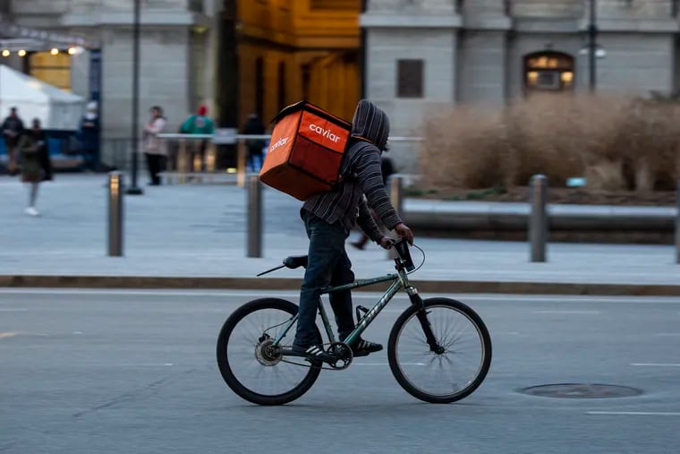 A biker delivery man rides through Penn Square near City Hall with a delivery backpack on Wednesday, Jan. 22, 2020. Grubhub, Postmates, and Doordash have been posting unauthorized menus on their sites which lead to misleading prices.