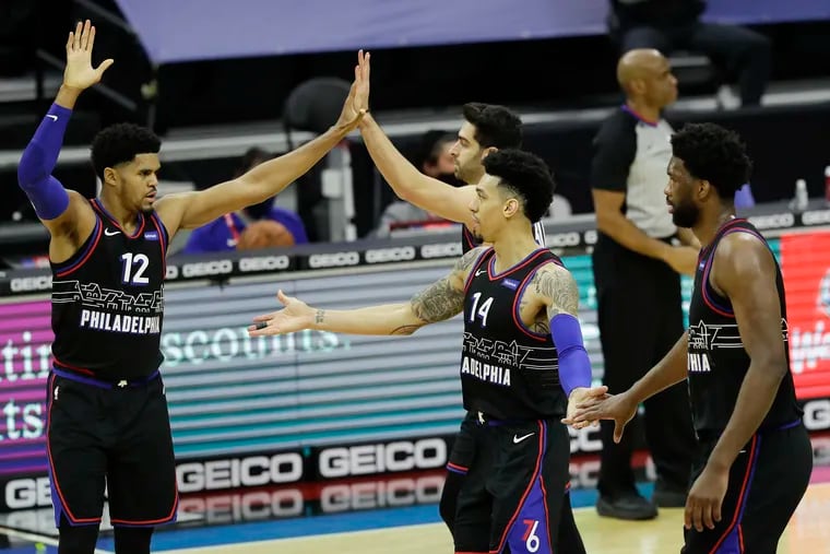 Sixers forward Danny Green (14) celebrated a three-point basket with teammates Tobias Harris (12), Furkan Korkmaz and center Joel Embiid (right) against the Brooklyn Nets on Saturday.
