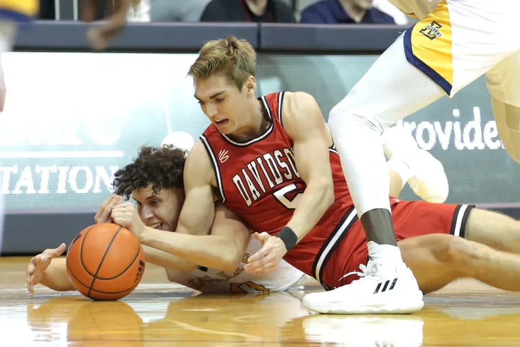 Andrés Marrero (left) of La Salle and Grant Huffman of Davidson go after a loose ball during the 1st half on Jan. 24, 2023.