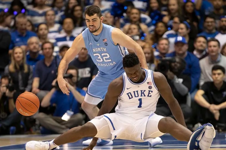 Duke's Zion Williamson (1) falls to the court in front of North Carolina's Luke Maye after his left sneaker blew out.