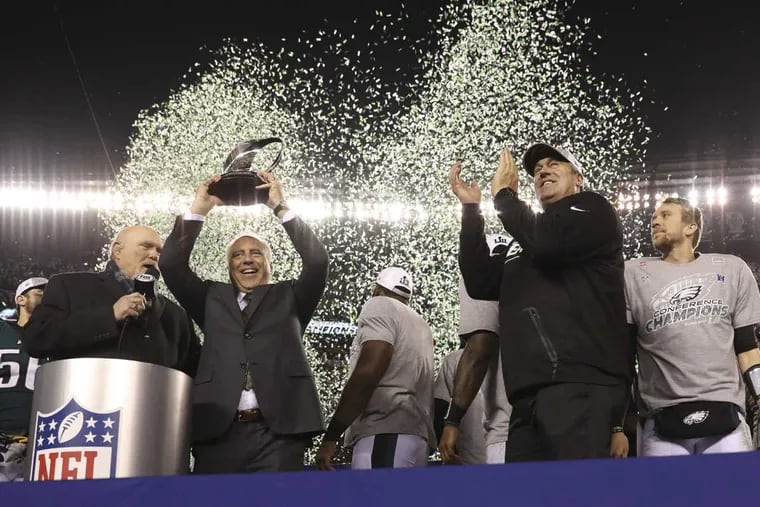 Philadelphia Eagles head coach Doug Pederson claps as owner Jeffery Lurie holds the NFC Championship trophy after the Eagles beat the Minnesota Vikings in the NFC Championship game on Sunday.