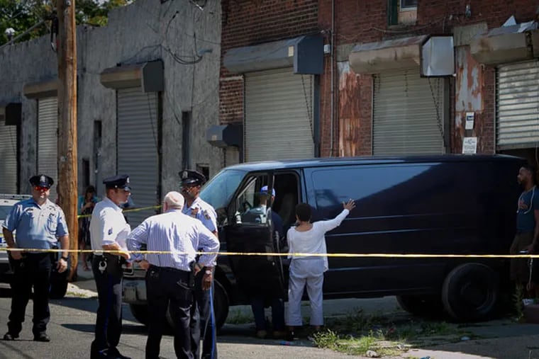 Philadelphia police were called to a small warehouse on 2600 block of
W. Hagert Street in the Strawberry Mansion section of the city on Tuesday, Aug. 25, 2015. The van in background was brought in to remove bodies discovered inside a warehouse. (ALEJANDRO A. ALVAREZ / Staff Photographer)