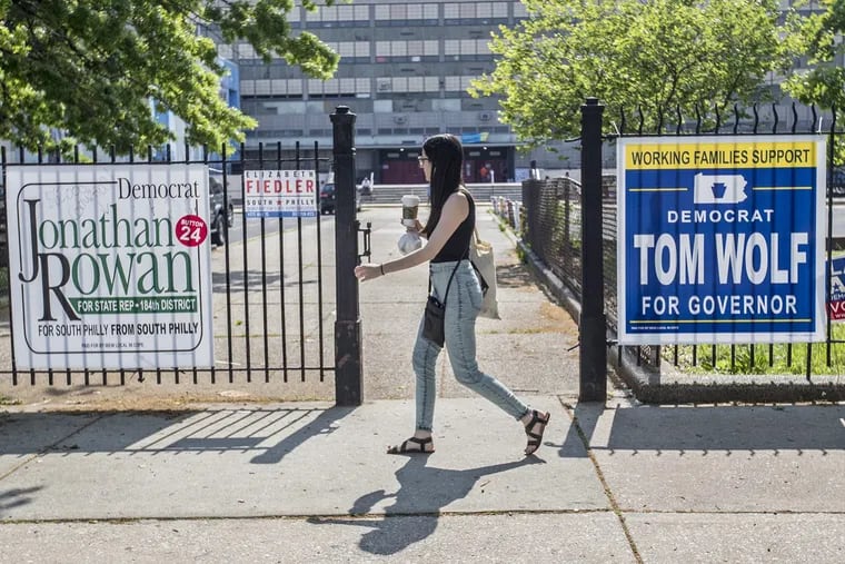 A pedestrian passes by the entrance to South Philadelphia High School where three different divisions of the 39th District have polling places in the school’s auditorium on this primary day , May 15, 2018.