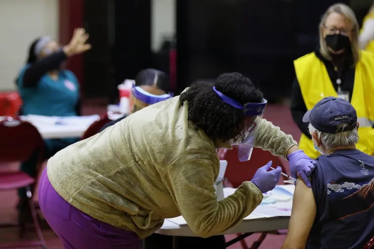 A health-care worker vaccinates a man at a community COVID-19 vaccination clinic run by the Philadelphia Department of Public Health at University of the Sciences' Bobby Morgan Arena in West Philadelphia on Feb. 27.