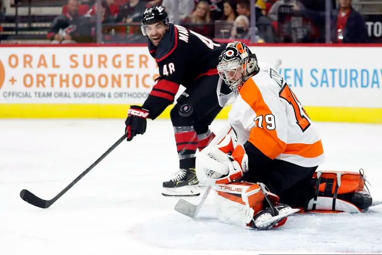 Flyers goalie Carter Hart makes one of his 39 saves as he stops Jordan Martinook in the second period Friday. Hart led the Flyers past host Carolina, 2-1.