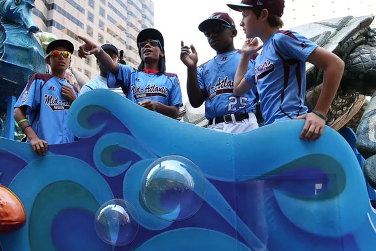 Teammates from the Taney Dragons ride a float during a parade in their honor in Philadelphia.