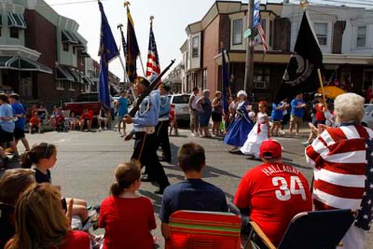 People watch veterans march past during a Memorial Day parade Monday, May 30, 2011, in the Bridesburg neighborhood of Philadelphia. (AP Photo/Matt Rourke)