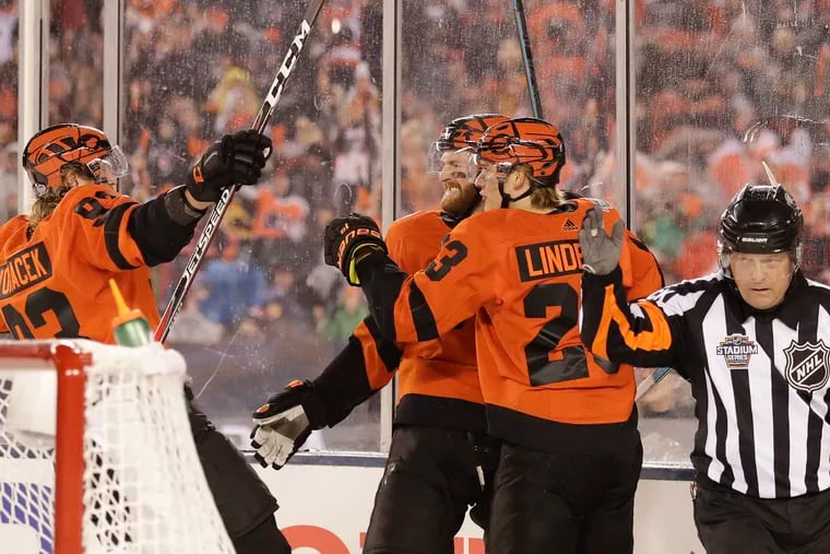 Flyers center Sean Couturier (center) celebrates his first-period goal Saturday night with teammates Oskar Lindblom and Jake Voracek against the Pittsburgh Penguins at Lincoln Financial Field.