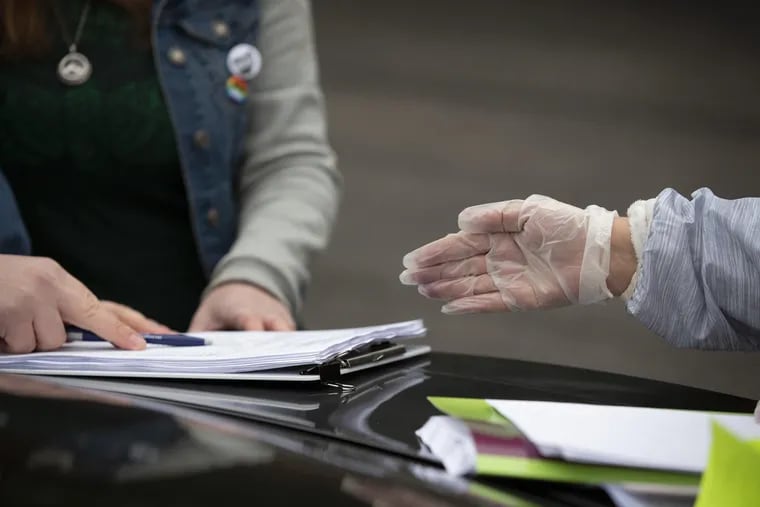 A title agent wears protective gloves as she helps a couple sign mortgage documents in Columbus, Ohio. Lenders are  raising their minimum credit score requirements fearing that  high unemployment will translate into mortgage defaults and late payments down the road.  (Adam Cairns/Columbus Dispatch/TNS)