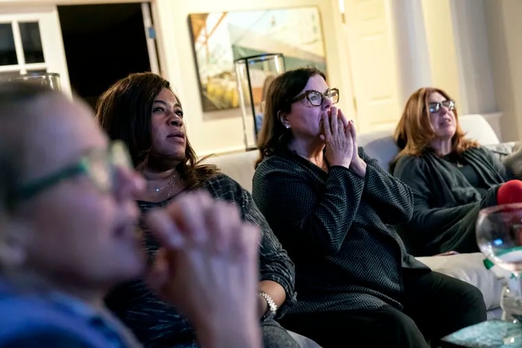 Supporters of Democratic presidential candidate former Vice President Joe Biden, from left, Kimber Bishop-Yanke, Leslie Esters-Redwine, Lori Goldman and Mimi Miletic, react to election results at a watch party in Bloomfield Hills, Mich., Tuesday, Nov. 3, 2020.