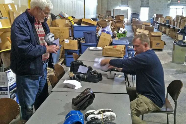 Ron Miller (left) and Steve Mannion, a volunteer from Downingtown, sort through some of the donations to the charity In Ian's Boots.