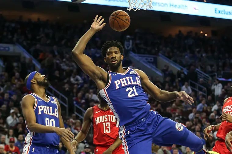 Sixers' Joel Embiid (21) gets fouled by Rockets' James Harden during the first quarter while Corey Brewer (00) is near by at the Wells Fargo Center on Monday.   STEVEN M. FALK / Staff Photographer