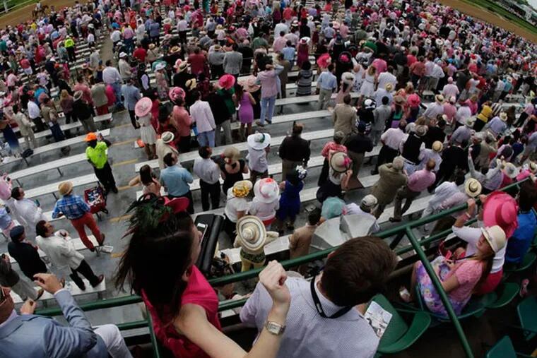 Spectators wait for the seventh race before the running of the 139th Kentucky Oaks at Churchill Downs Friday, May 3, 2013, in Louisville, Ky. (Charlie Riedel/AP)