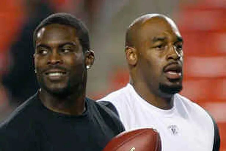 Michael Vick and Donovan McNabb (right) as Eagles a year ago. McNabb says he expects to be cheered at the Linc.