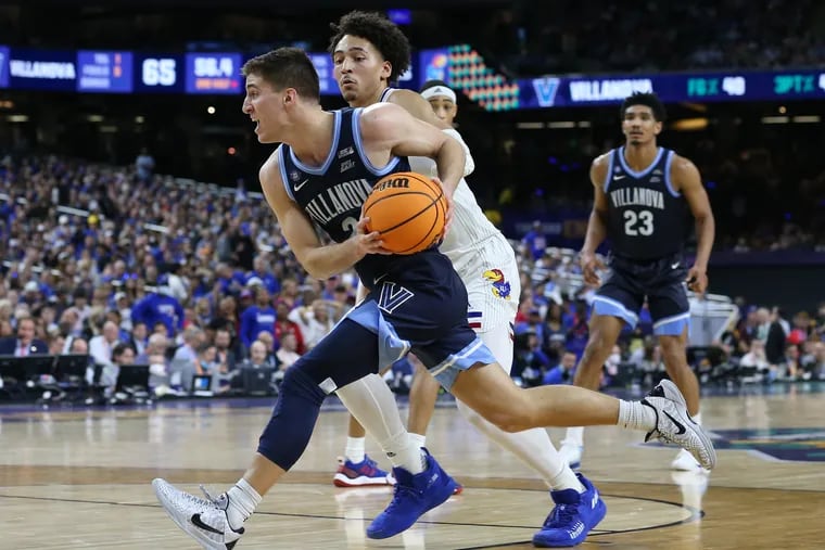 Collin Gillespie, left, of Villanova drives by Jalen Wilson of Kansas during the 2nd half of their national semifinal game of the NCAA Tournament on  April 2, 2022 at the Superdome in New Orleans.