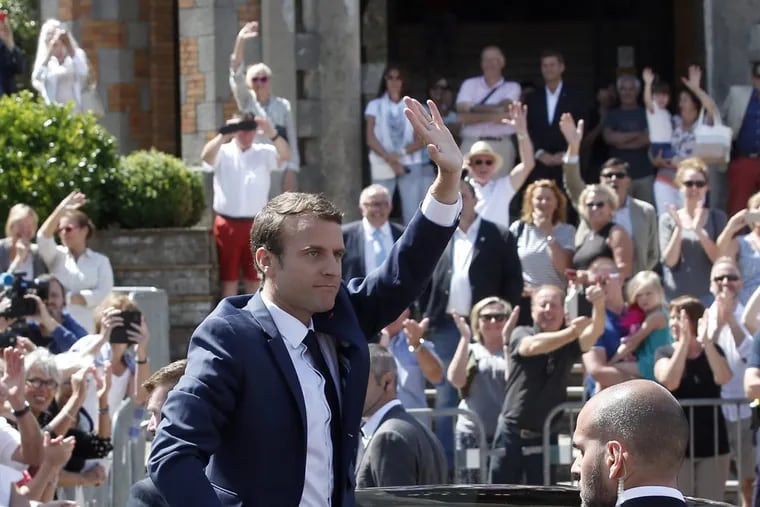 French President Emmanuel Macron waves as he leaves a polling station on June 11.