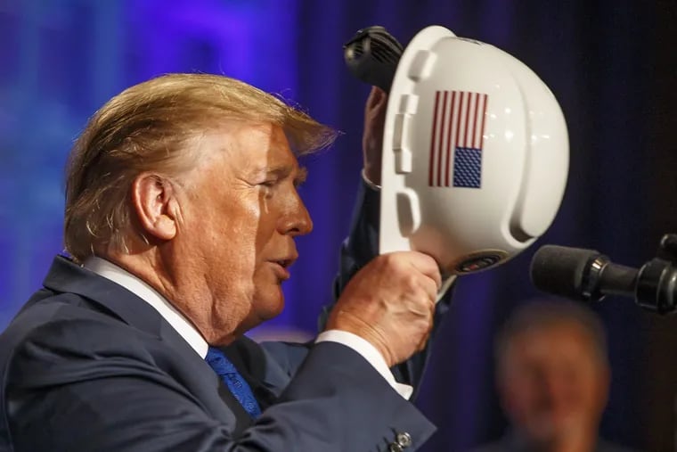 President Donald Trump dons a hardhat with an American Flag and a Presidential Seal on it as he speaks to the members of the National Electrical Contractors Association on October 2, 2018, in Philadelphia. MICHAEL BRYANT / Staff Photographer